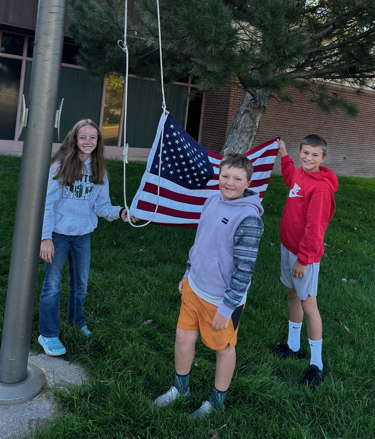 5th Grade students raising the American Flag in front of the elementary school